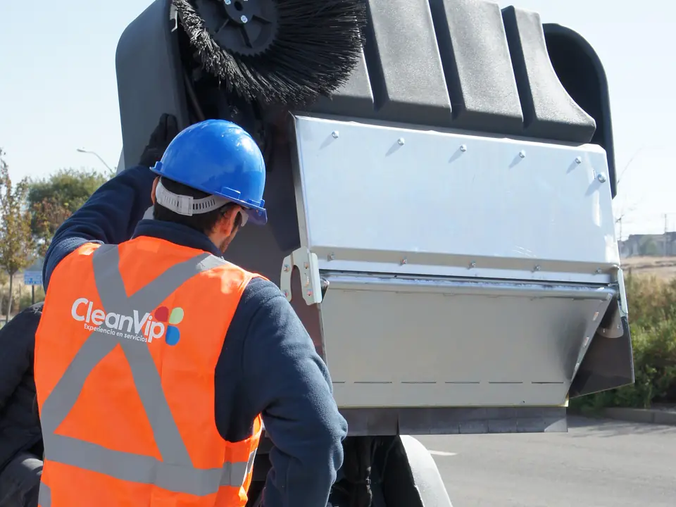 Trabajador de CleanVip con casco y chaleco reflectante operando maquinaria