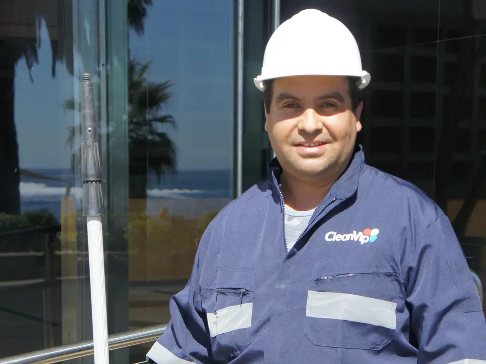 Trabajador de CleanVip con casco, uniforme y equipo de trabajo en altura