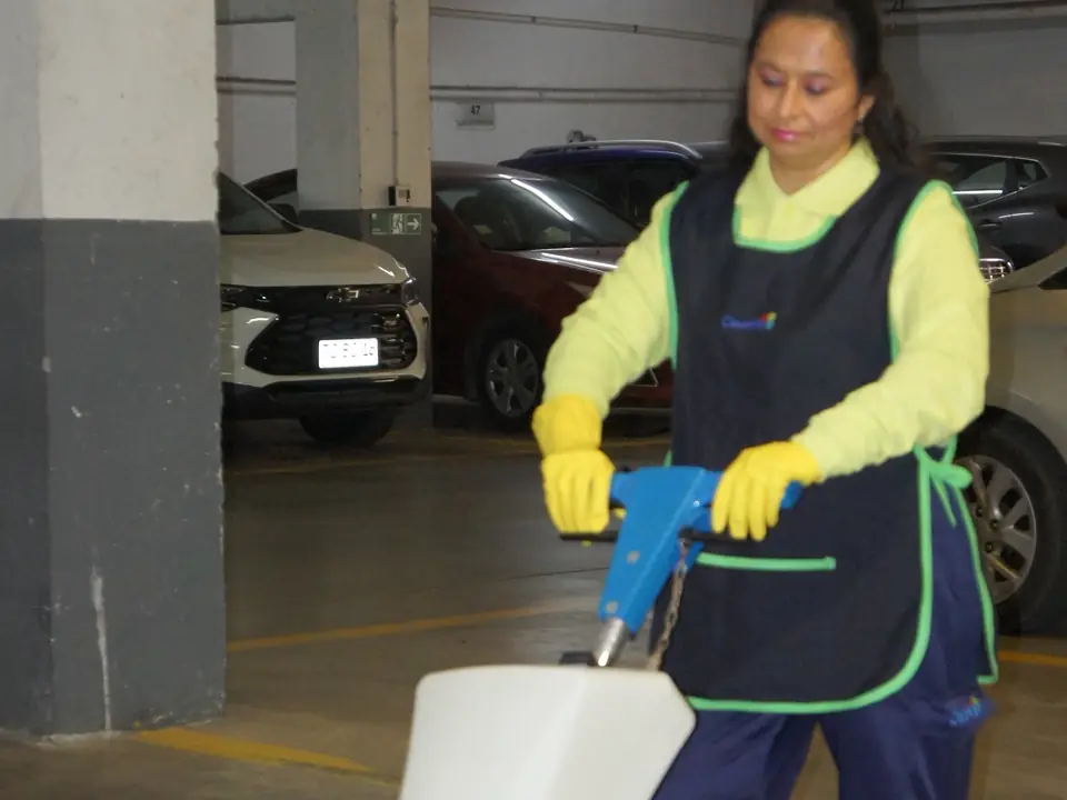 Trabajadora de CleanVip operando una abrillantadora en un estacionamiento
