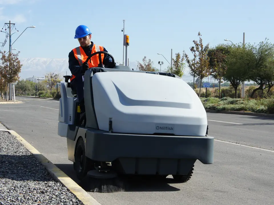 Trabajador de CleanVip operando una barredora en una vía exterior