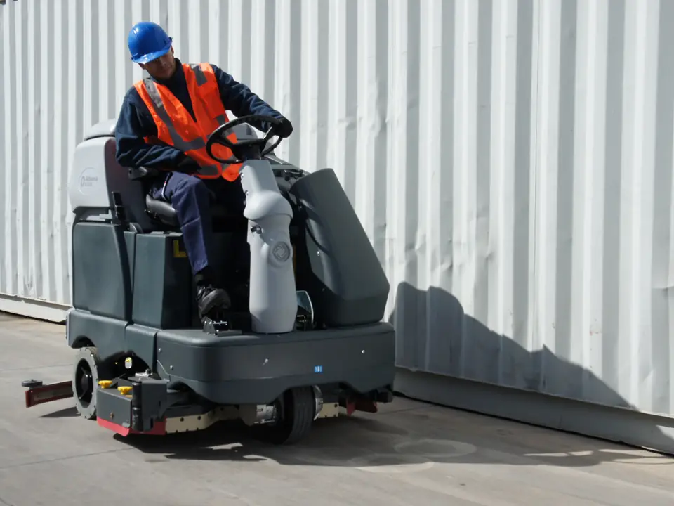Trabajador de CleanVip fregando la explanada de una nave industrial